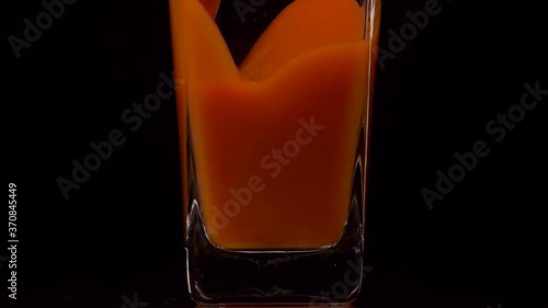 Wallpaper Mural Sip It. Super slow motion shot of pouring tomato juice into a transparent glass against black background. Close up. Healthy drink, vitamins concept Torontodigital.ca