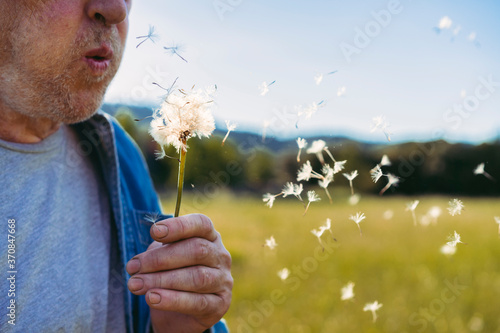 Senior man blowing blowball