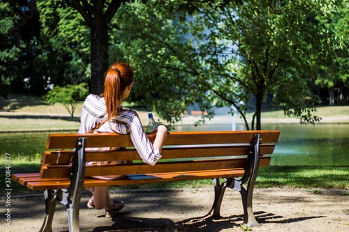 young woman sitting on bench in park