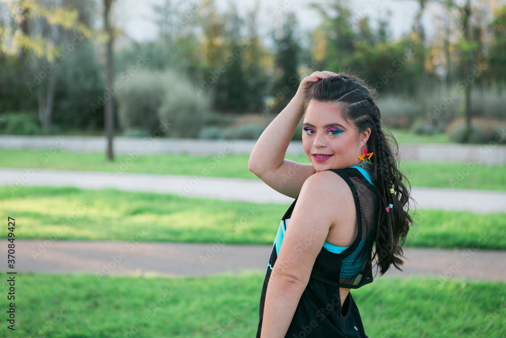 Teenager girl with down syndrome wearing 80's colorful make-up and clothes