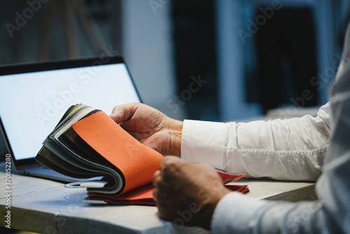 Architect choosing textile samples in office, close up