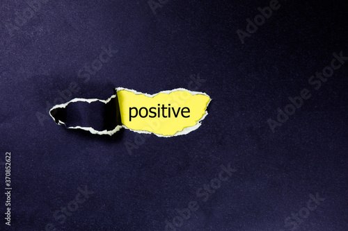 positive word under torn paper