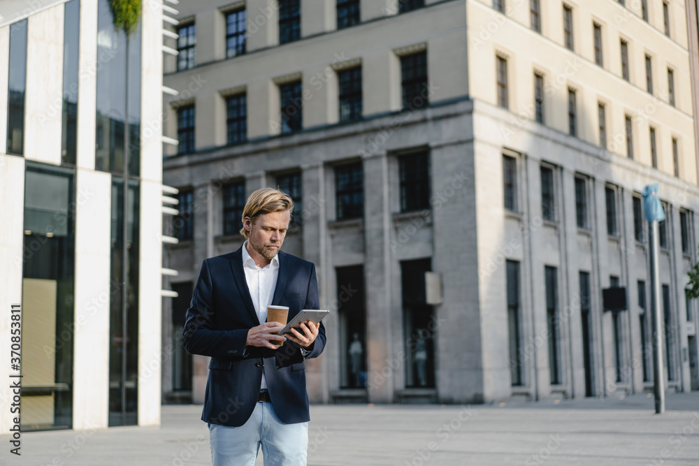 Businessman with takeaway coffee and tablet in the city Businessman with takeaway coffee and tablet in the city