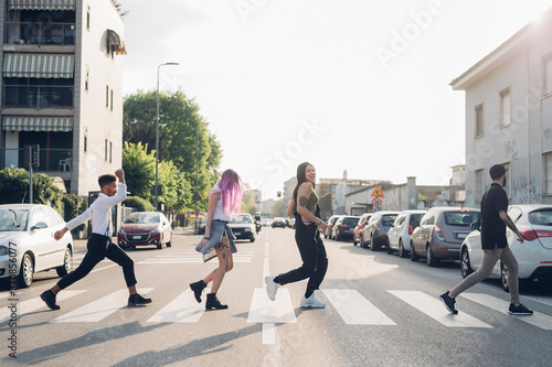 Group of friends crossing a street in the city photo