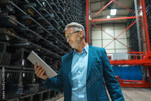 Wallpaper Mural Mature businessman using tablet in a factory Torontodigital.ca