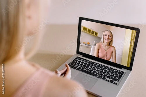 Back view of business woman talking to her colleague in video conference at home. Online conference chatting work colleagues. Training video call on a web camera.