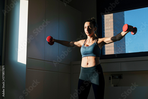 Woman doing dumbell training at home photo