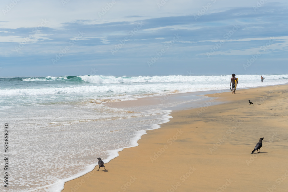 surfer on the beach, sunny day and cloudy sky, Arugam Bay, Sri Lanka surfer on the beach, sunny day and cloudy sky, Arugam Bay, Sri Lanka