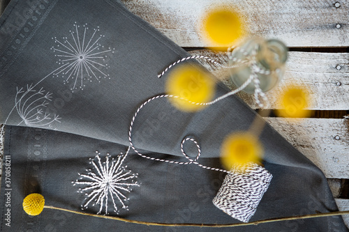 Embroidered fabric and bottleÔøΩwith blooming billy buttons photo