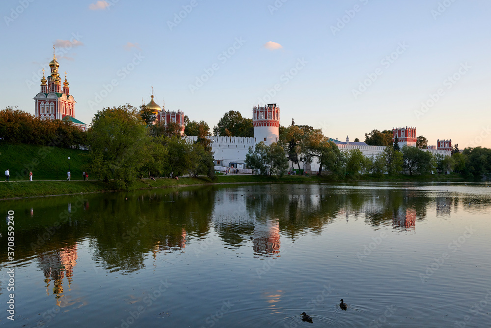 Novodevichy Convent behind the Big Novodevichy Pond in the reflections of the setting sun Novodevichy Convent behind the Big Novodevichy Pond in the reflections of the setting sun
