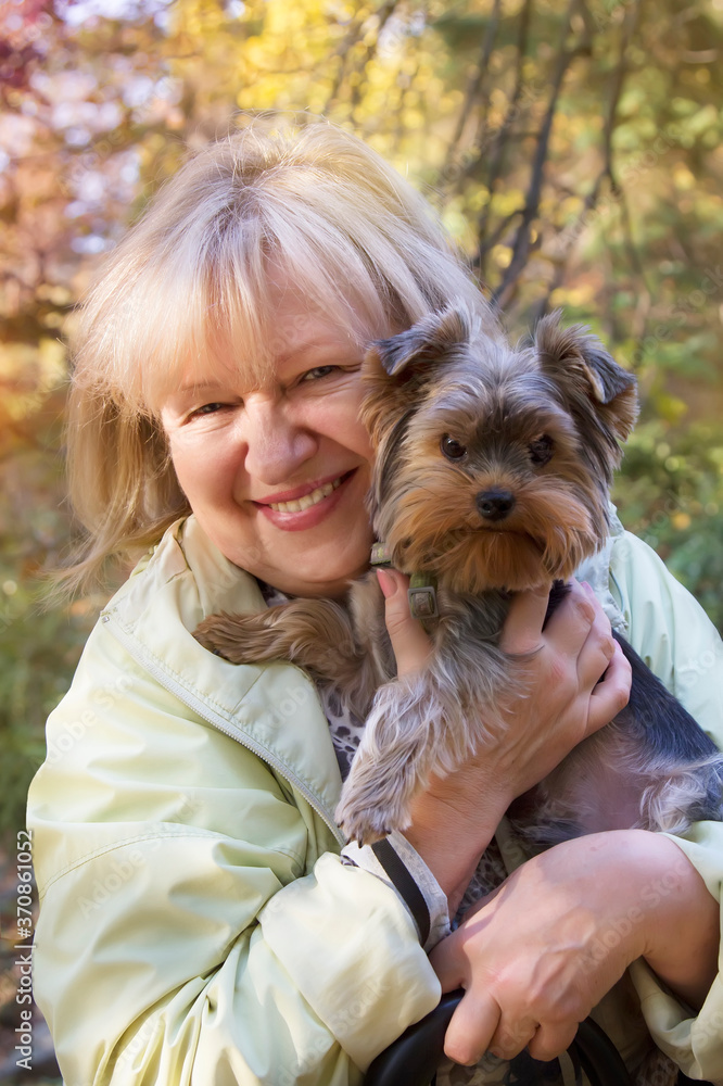 Beautiful smiling woman is holding her pet Yorkshire terrier Beautiful smiling woman is holding her pet Yorkshire terrier