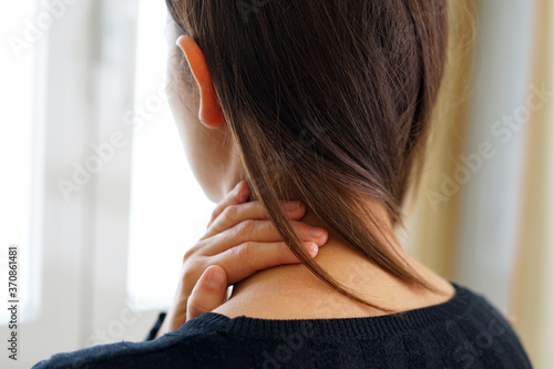 Woman with neck pain touching her neck. Neck pain concept.