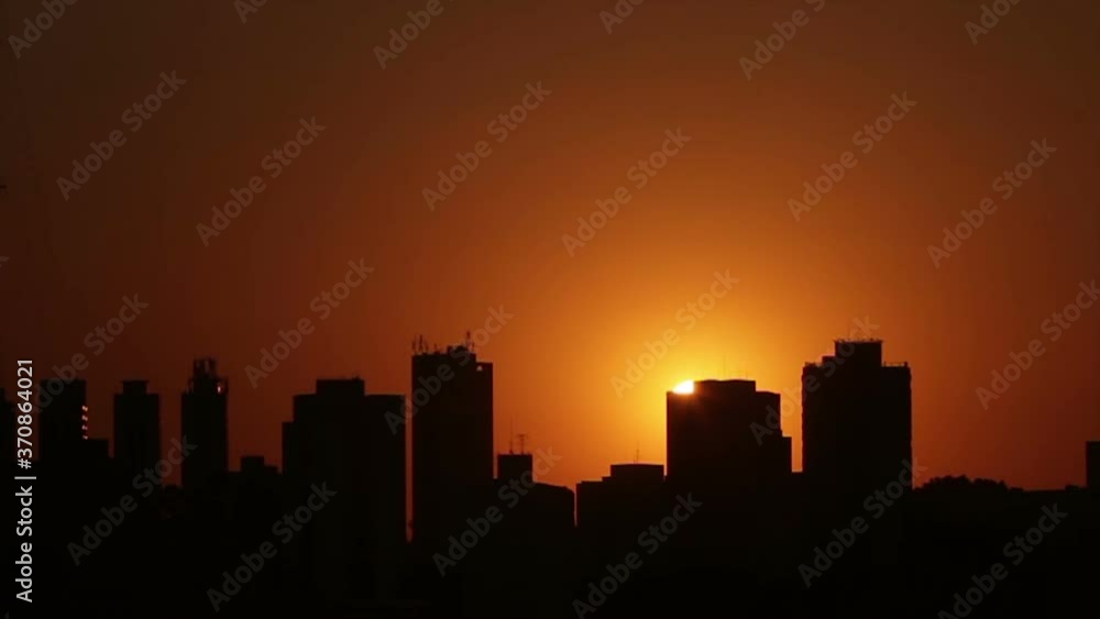 time lapse sunset between buildings, orange sky, cloudless time lapse sunset between buildings, orange sky, cloudless