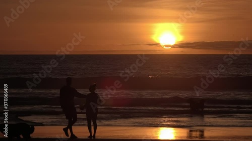 Family With Dogs Enjoying A Beautiful Sunset At The Beach