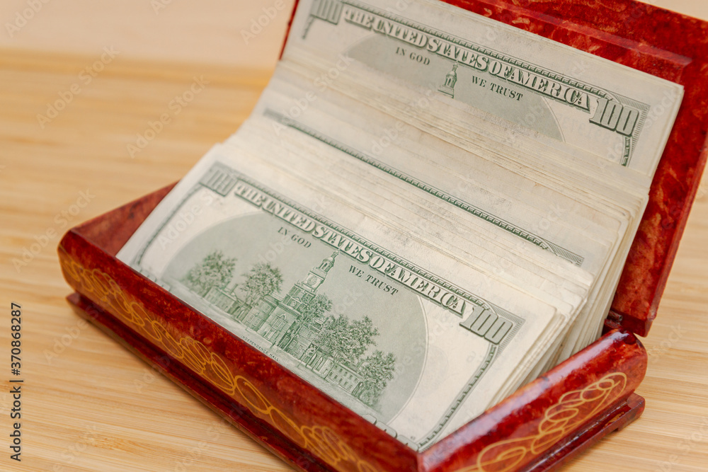 American hundred dollar bills in large quantities in a wooden box American hundred dollar bills in large quantities in a wooden box