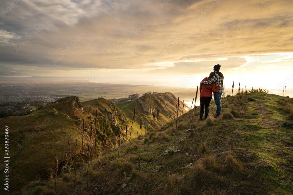 Fototapeta premium Couple embracing each other on the peak on a mountain