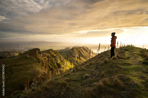 Young woman staring at the beautiful landscape from the top of a mountain. Te Mata Peak, New Zealand photo