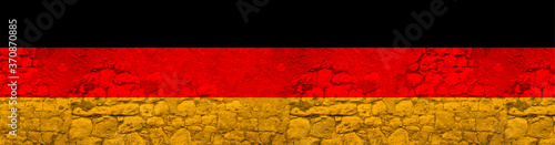 seamless panorama of the national flag of the state of Germany on an old stone wall with cracks, the concept of tourism, emigration, economy, politics, global world trade