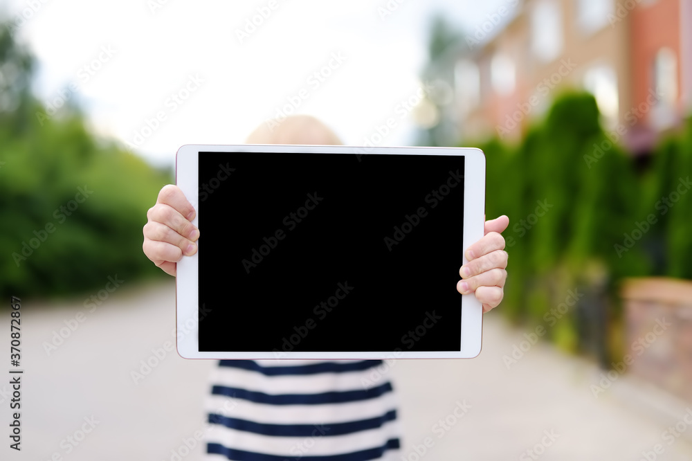 Child holding with hands tablet pc with black screen for copy space and free text. Space for your advertising or information. Empty device screen. Child holding with hands tablet pc with black screen for copy space and free text. Space for your advertising or information. Empty device screen.