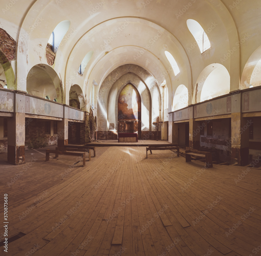Inside an abandoned church. ancient interior of religious building. benches and altar. wooden cross stands in the corner