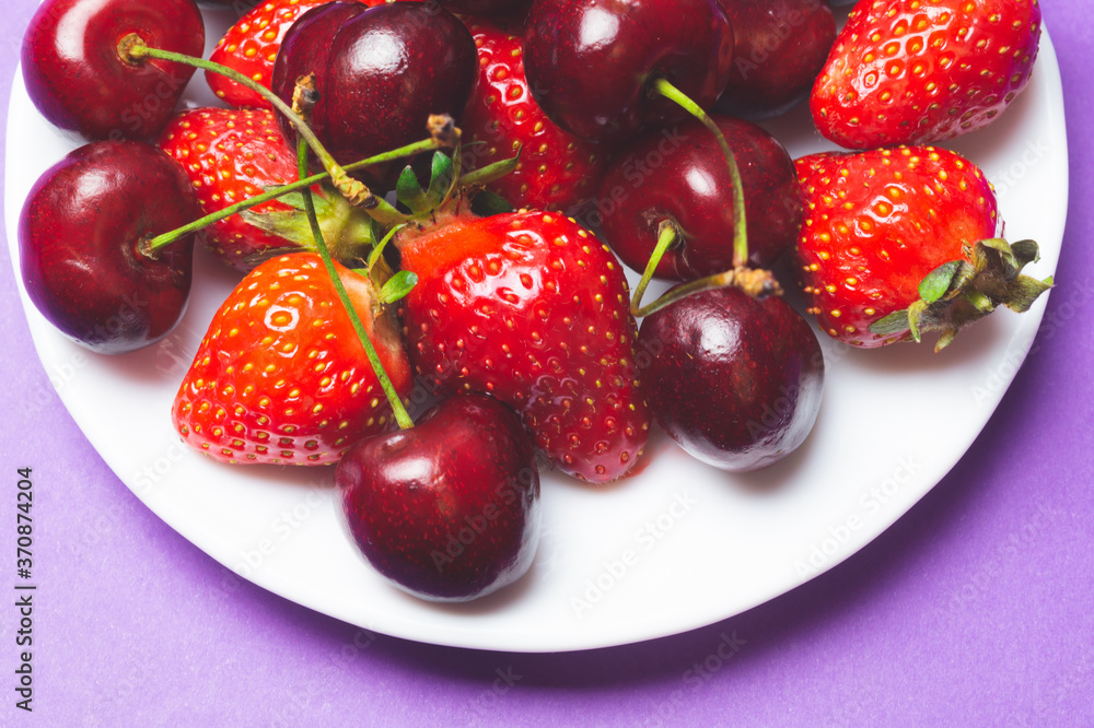 Cherries and strawberries on the white plate Cherries and strawberries on the white plate