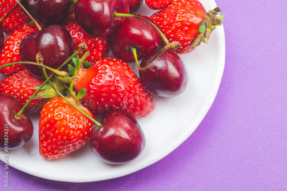 Cherries and strawberries on the white plate Cherries and strawberries on the white plate