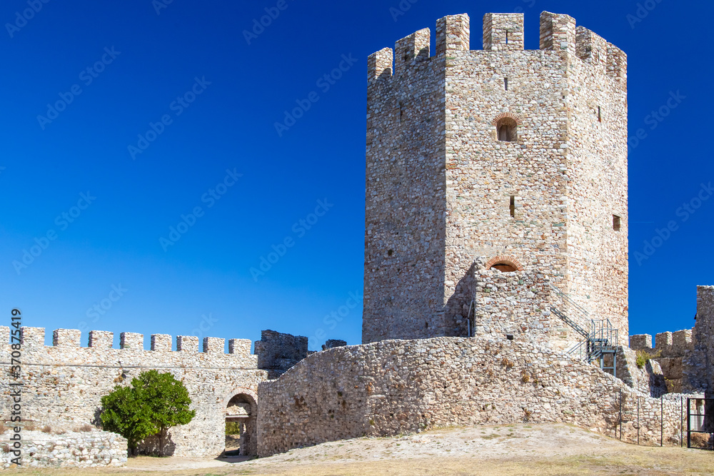 Greece. Platomonas. Fortress Platomons. Tower of a stone fortress. Ancient fortress on Mount Olympus. Stone fortress on the background of blue sky. Protective structure of ancient Greece. Sights