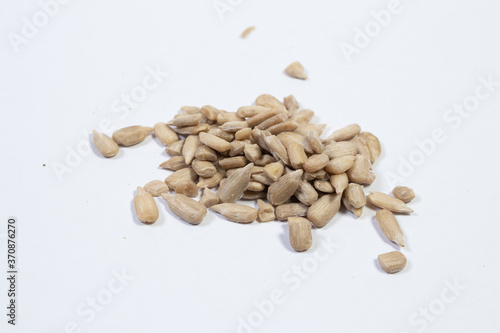 peeled sunflower seeds on white background.