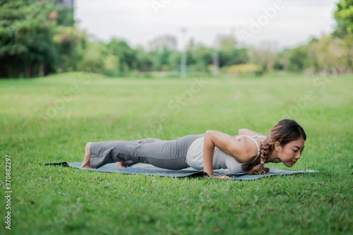 Healthy women doing yoga in the moring at the park . concept healthy and outdoor activity. © Rattanachoat