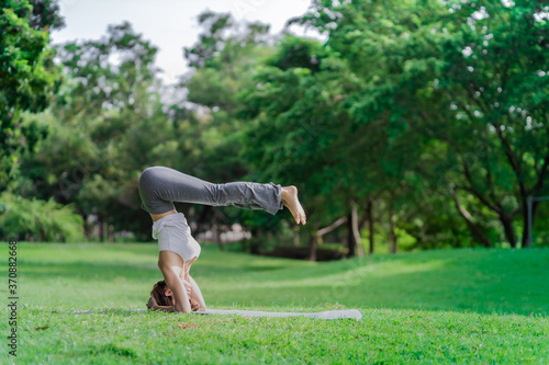 Healthy women doing yoga in the moring at the park . concept healthy and outdoor activity.