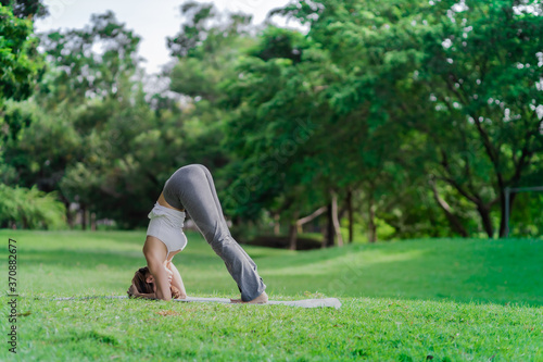 Healthy women doing yoga in the moring at the park . concept healthy and outdoor activity.