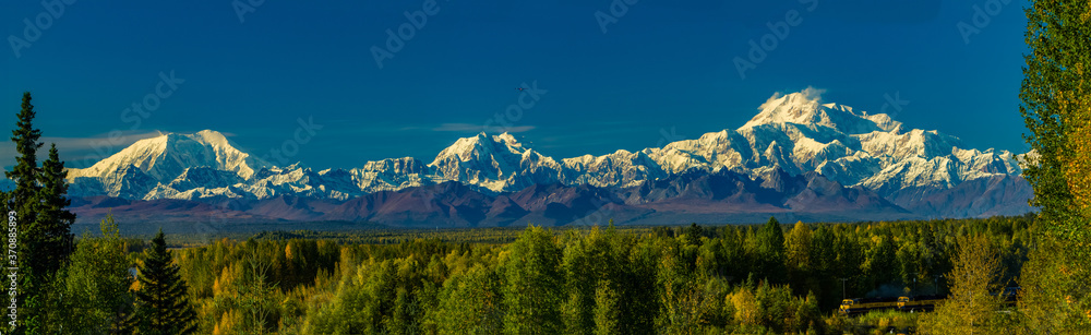 Denali, Mt Hunter and Mt Foraker in the alaska range, and the Alaska railway train.    Denali is the highest mountain peak in North America, with a summit elevation of 20,310 feet