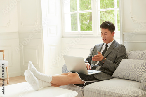 Canvas Print young asian corporate executive working from home video chatting using laptop
