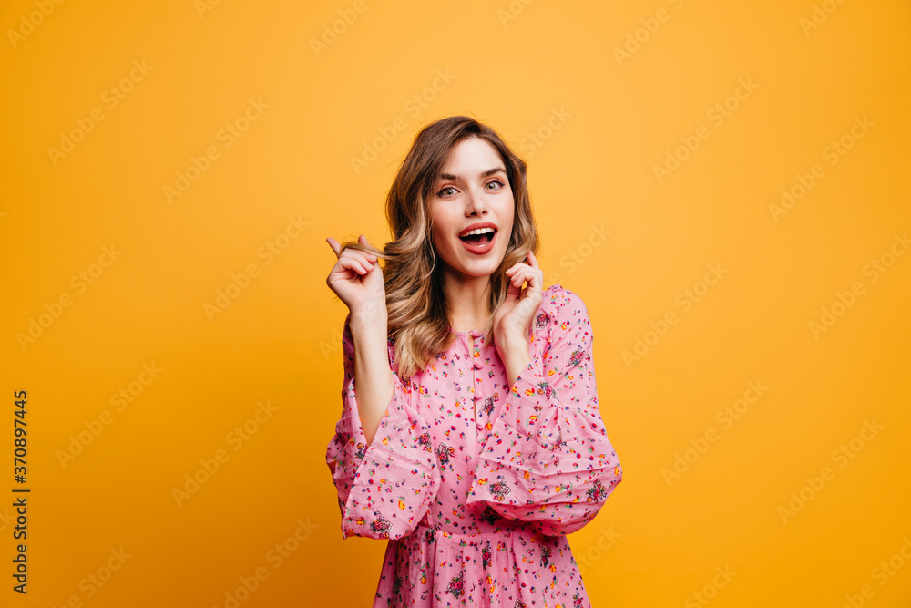 Interested white girl with wavy hairstyle expressing interest. Indoor photo of magnificent romantic woman in pink dress. Interested white girl with wavy hairstyle expressing interest. Indoor photo of magnificent romantic woman in pink dress.
