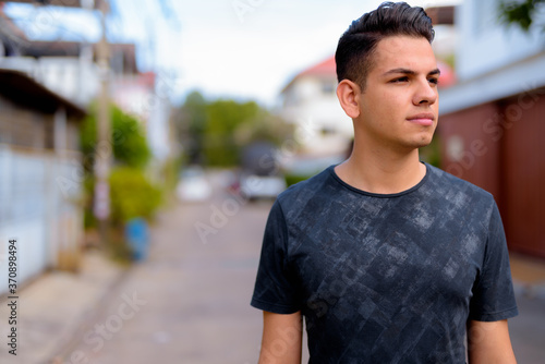Young handsome multi ethnic man in the streets outdoors