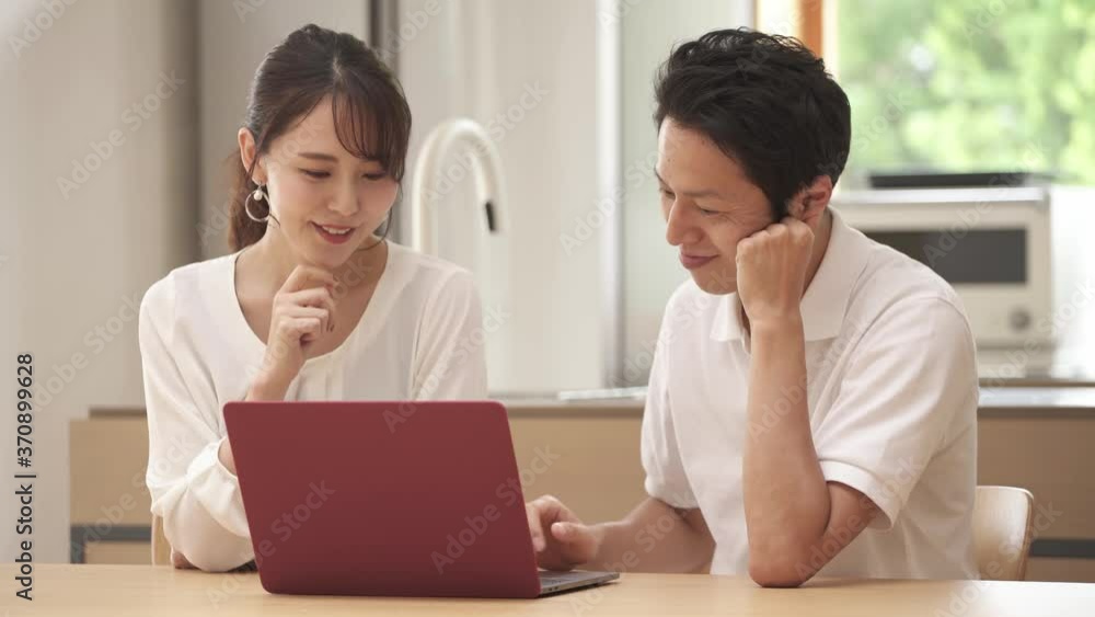 ノートパソコンを使う新婚夫婦 ノートパソコンを使う新婚夫婦