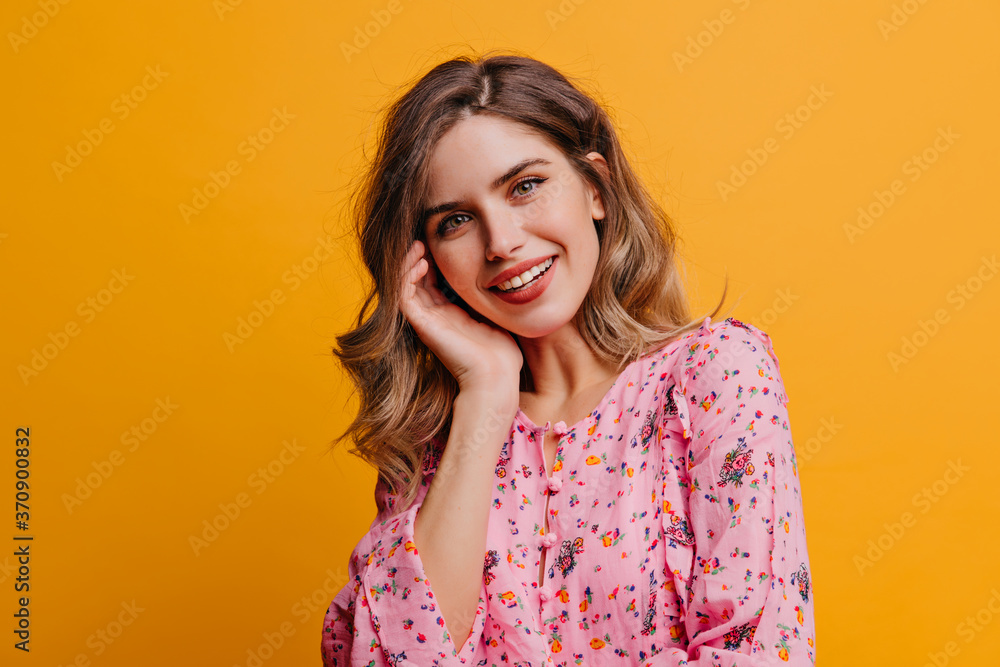 Cute beautiful woman with wavy hair laughing on yellow background. Indoor photo of pretty white girl wears pink blouse. Cute beautiful woman with wavy hair laughing on yellow background. Indoor photo of pretty white girl wears pink blouse.