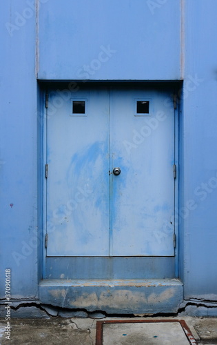 The weathered blue door on cracked cement base © evergreentree