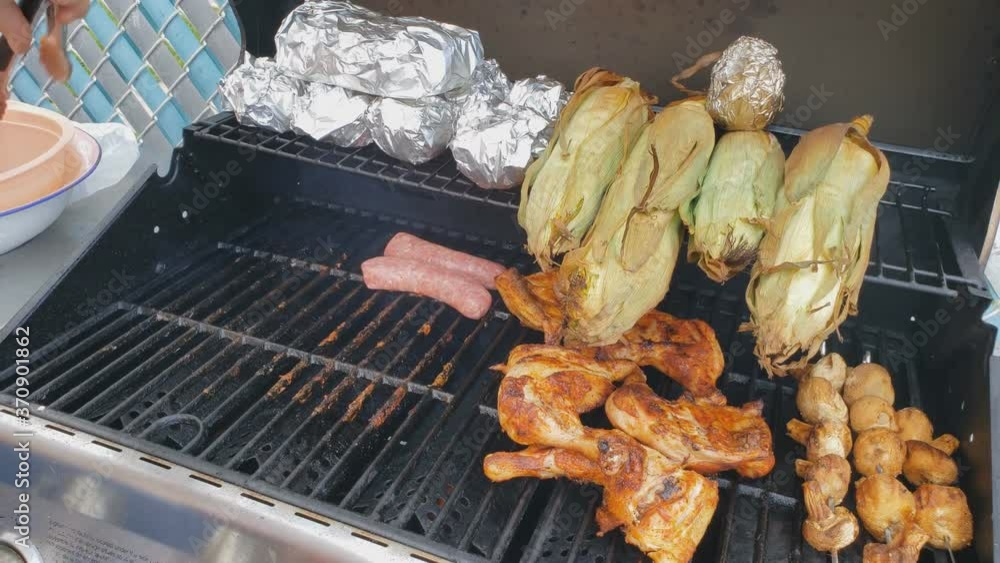 Home cooking Transferring white or bratwurst sausage onto gas grill