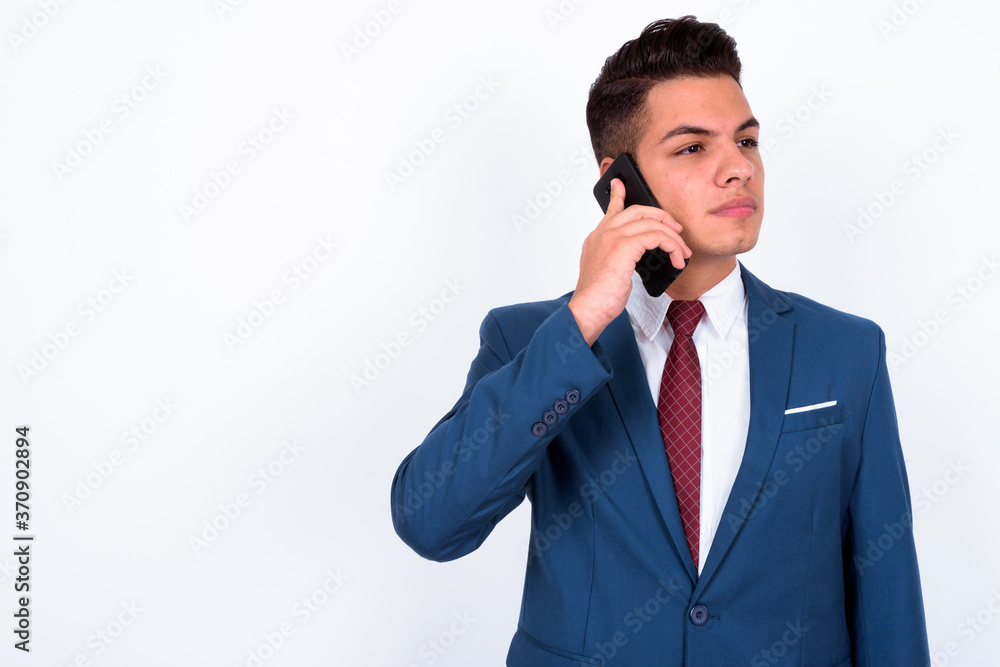 Portrait of young handsome multi ethnic businessman in suit talking on the phone Portrait of young handsome multi ethnic businessman in suit talking on the phone