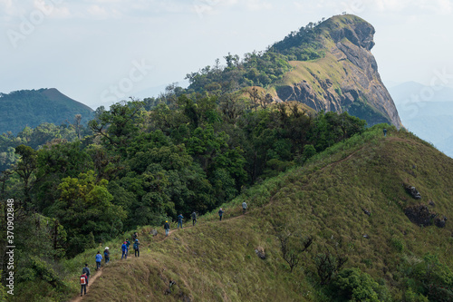 Group of backpackers spending their leisure activity hiking on the mountain ridge