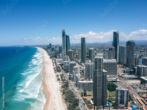 An aerial view of Surfers Paradise on the Gold Coast, Australia, a sunset view of blue ocean with beautiful waves and white sand beach people sanbathing  © Ada