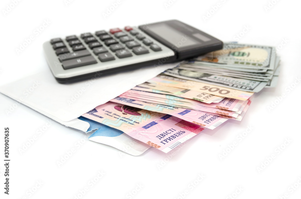 calculator, dollars and hryvnia in a white envelope on a white background. calculator, dollars and hryvnia in a white envelope on a white background.