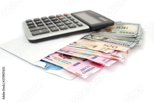 calculator, dollars and hryvnia in a white envelope on a white background.