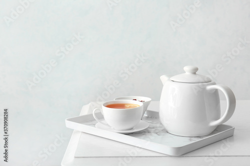 Cup of hot beverage, teapot and jam on table © Pixel-Shot
