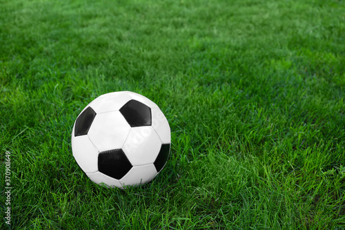 Soccer ball on green grass outdoors © Pixel-Shot