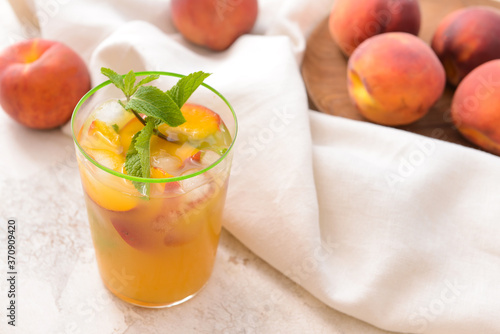 Glass of tasty peach juice on white background