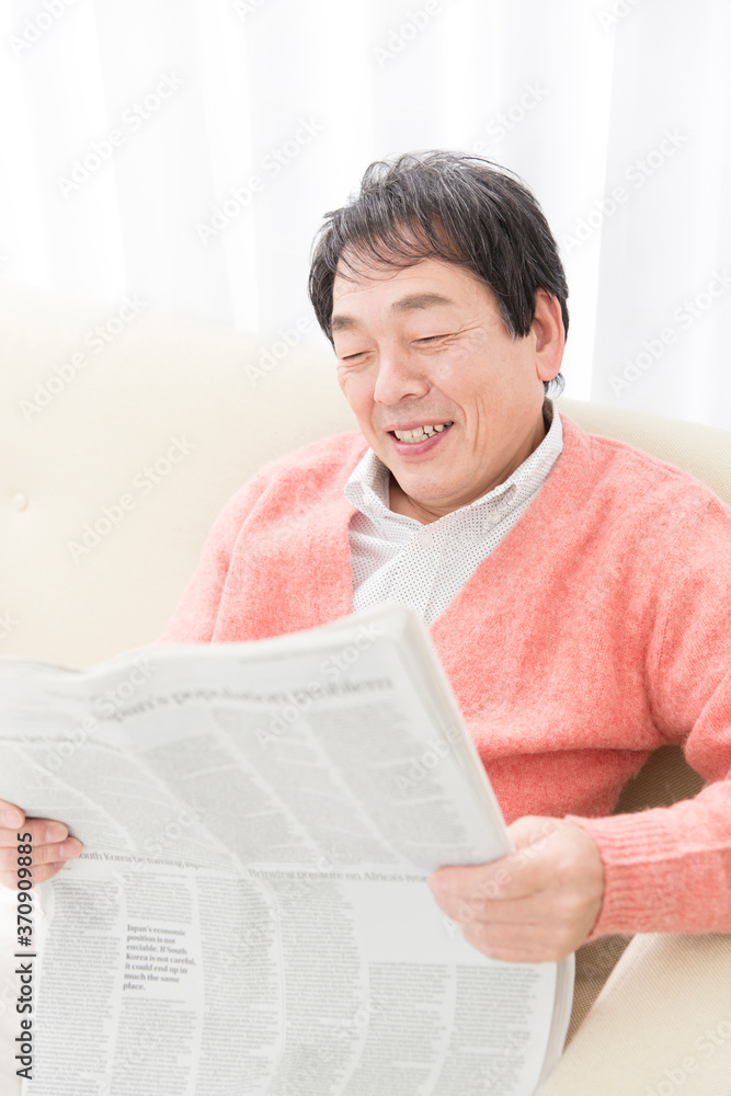 Obraz premium 新聞を読むミドル男性