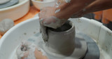 Hand work on pottery wheel, shaping a clay pot