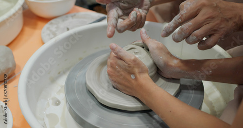 Hand work on pottery wheel, shaping a clay pot photo